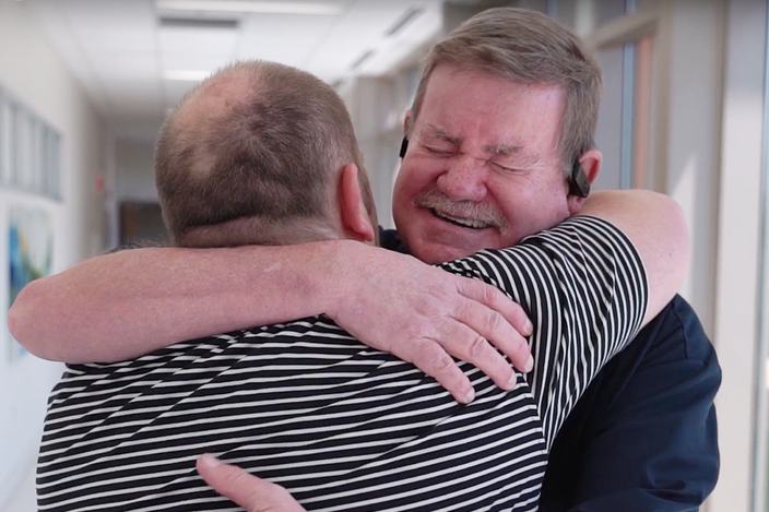 a-man-smiling-hugging-another-man