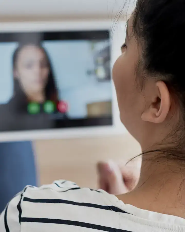 a woman holding a tablet with a video chat