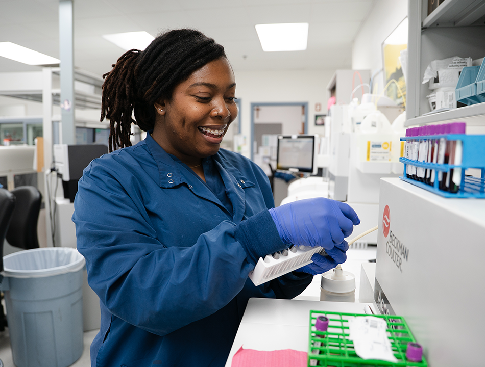 A-woman-in-scrubs-holding-test-tubes A-woman-in-scrubs-holding-test-tubes