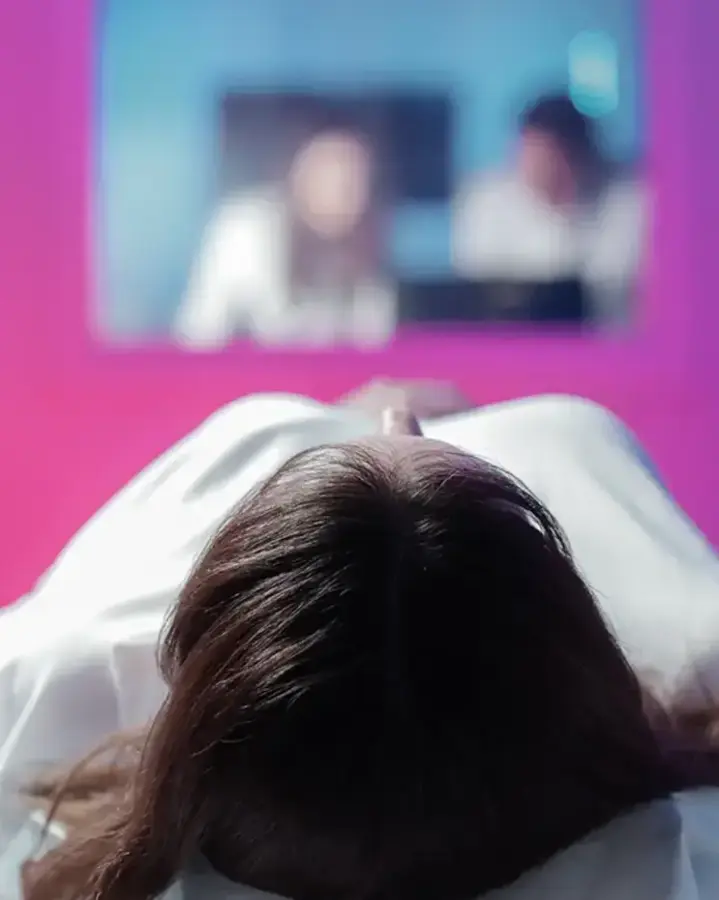 a woman in a white shirt is sitting in a mri