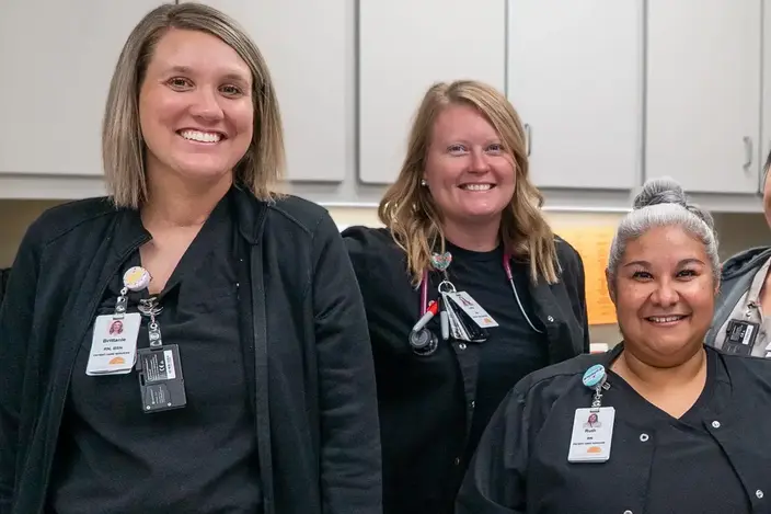 four woman in scrubs smiling