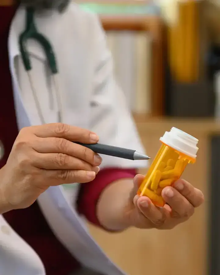 a doctor is holding a prescription bottle